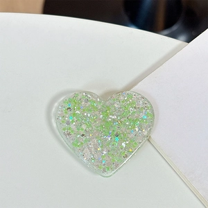 Macro shot of green heart-shaped phone grip with glitter resin and silver sparkles