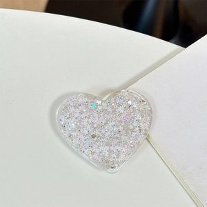 Close-up of heart-shaped phone grip with silver glitter and star sequins inside