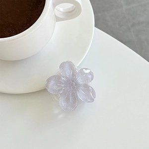 Detail of a purple glitter flower phone grip with a translucent finish and texture