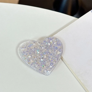 Macro view of heart-shaped phone grip with iridescent silver and purple glitter flakes