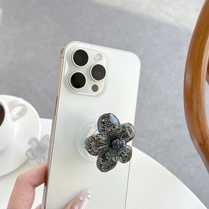 Sparkling black flower phone grip with glitter finish on a white mobile phone