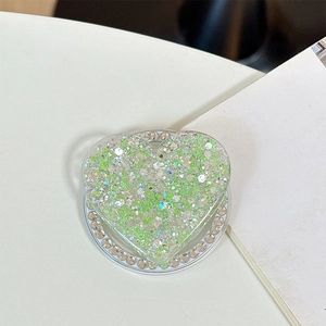 Detail view of heart-shaped phone grip with green sequins and silver rhinestone edges