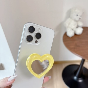 Close-up of heart-shaped folding phone grip with makeup mirror in vibrant lemon yellow