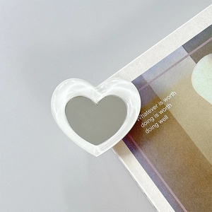 Macro shot of heart-shaped phone grip with pearl-like finish and built-in vanity mirror