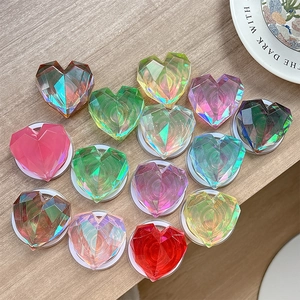Magnetic 3D laser heart phone grip stands in gradient colors on wood surface