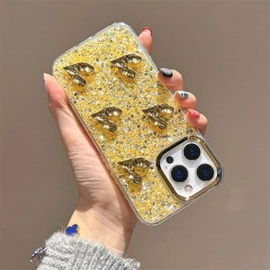 Close-up of golden glitter iPhone case with five 3D heart-shaped metal charms and lens border