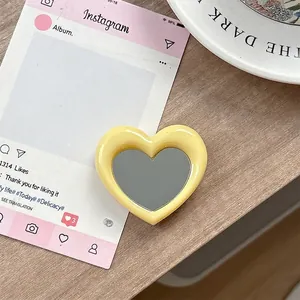 Detail van een gele hartvormige draagbare spiegel en mobiele telefoonhouder-accessoire