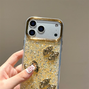 Detail of iPhone glitter case with three-dimensional golden bows and sparkly finish