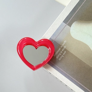 Close-up of heart-shaped red phone socket mirror on a modern minimalist background