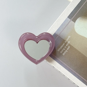 Detail of a purple heart-shaped foldable phone grip and makeup mirror with resin frame