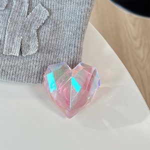 Detail shot of a 3D laser heart phone grip with iridescent faceted surface on fabric