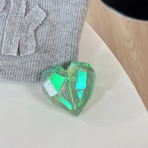 Detail of 3D iridescent green heart magnetic phone grip with faceted gem-like surface