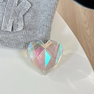 Close-up of a 3D holographic heart phone grip with faceted surfaces and a transparent base