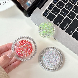 Colorful glitter round rhinestone phone grip socket stands displayed on a desk