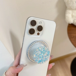 Close-up of blue glitter phone socket with star sequins and rhinestone border on a phone