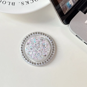 Close-up of a round phone grip featuring colorful glitter and a sparkling rhinestone border