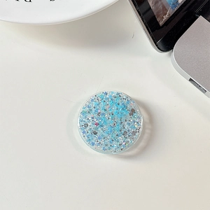 Macro detail of round light blue phone grip holder with sparkling glitter star sequins