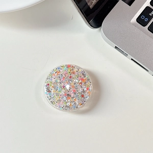 Close-up of circular phone grip featuring colorful star sequins and silver glitter detail