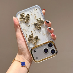 Dettaglio custodia iPhone con fiocchi dorati e inserti in foglia d'oro scintillante