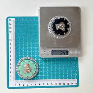 Detail view of 5cm bear phone grips showing black and green colors with crystal inlay
