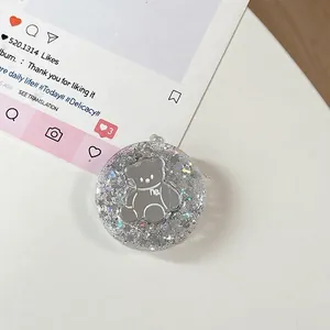 Detailopname van zilveren glitter telefoonhouder met een spiegelend beerontwerp