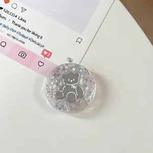 Detailopname van ronde hars telefoonhouder met glitters, sterren en een grijze berenprint