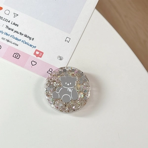 Detail van ronde telefoonhouder met glitters en zilveren beertje motief