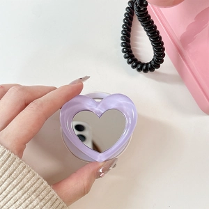 Detail of purple heart-shaped phone grip with mirror center on white background
