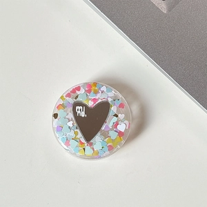 Detail of round phone socket featuring heart-shaped mirror with mine lettering and sequins