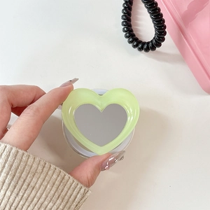 Detail of heart-shaped magnetic phone grip with vanity mirror in pale green finish