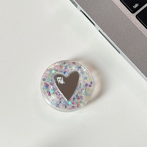 Detail of a round acrylic phone grip with colorful sequins and heart-shaped mirror
