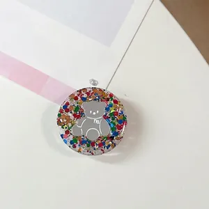 Detail van ronde hars telefoonhouder met grijze beer en kleurrijke glitter pailletten