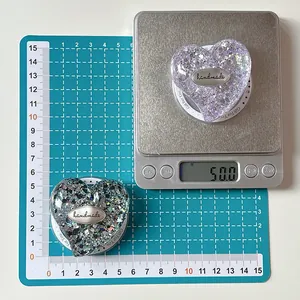 Detailed scale measurement showing weight and 5.5cm size of glitter heart phone grip