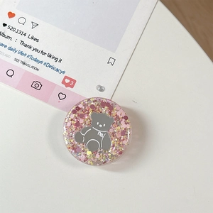 Detailopname van een ronde glitter telefoonhouder met een schattig grijs beertje