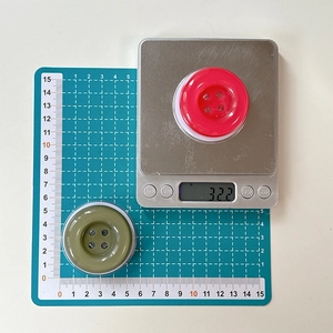 Macro shot showing oversized resin candy-colored button phone stand weight and diameter scale
