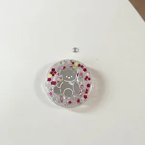 Macro-opname van ronde hars telefoonhouder met zilveren beer en roze glitterbloemen