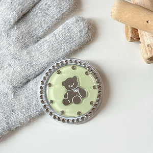 Close-up of a mint green phone grip with a cute brown bear and rhinestone border