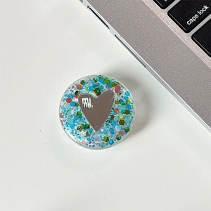 Detail of a sparkling heart mirror phone grip with blue glitter and 'mine.' text