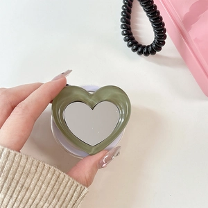 Detail of heart-shaped phone grip with green marble texture and integrated mini mirror