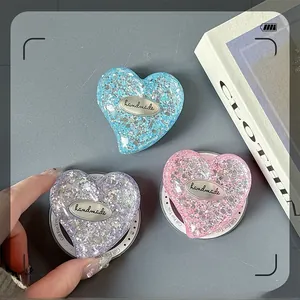 Macro shot of handmade heart-shaped sequin phone grips in blue, purple, and pink colors