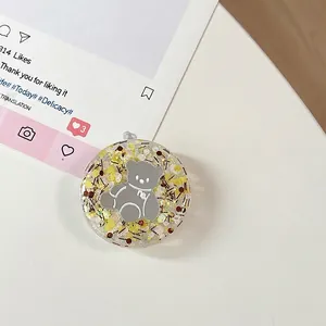 Detailweergave van een ronde beer telefoonhouder met sprankelende gele glitters binnen