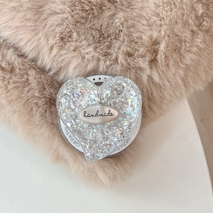 Macro shot of heart-shaped glitter phone grip with handmade tag and gift motif details