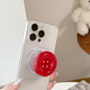 Detail of a bright red candy-colored button phone socket grip on a white smartphone