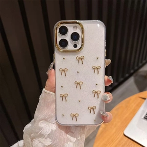 Close-up of glitter iPhone case featuring gold bow decorations and camera lens protection