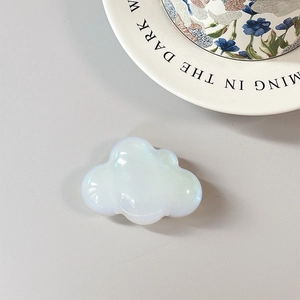 Detail of a cloud-shaped phone socket with iridescent opal finish on a gray background