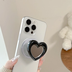 Glossy black heart-shaped phone socket with mirror surface on white smartphone