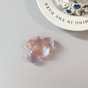 Close-up of a pink iridescent bear-shaped phone grip with a laser aurora finish