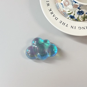 Detailed view of iridescent cloud phone grip with vibrant holographic finish on desk