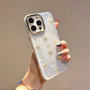 Transparent iPhone case with golden 3D bows and glitter finish held in hand