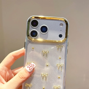 Detailed close-up of transparent iPhone case with golden bow decorations and beads